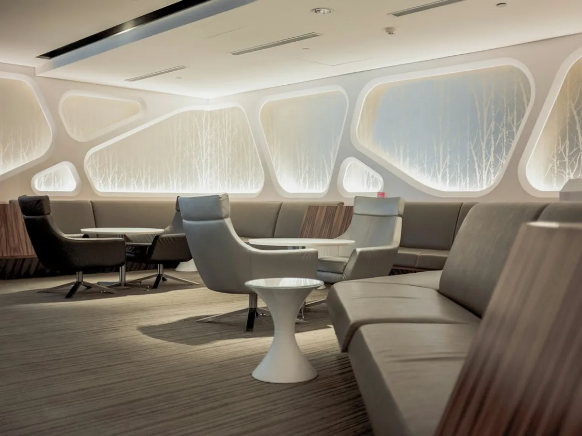 A curved white lounge with armchairs and soft lighting